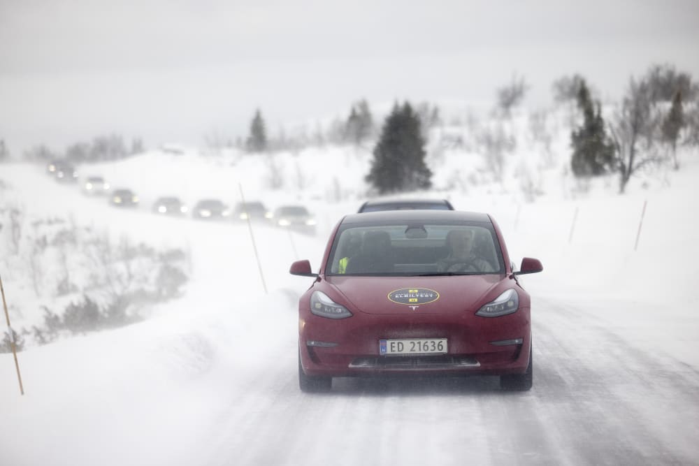 Bildet viser en rød Tesla Model 3 SR forfra i vinterføre.